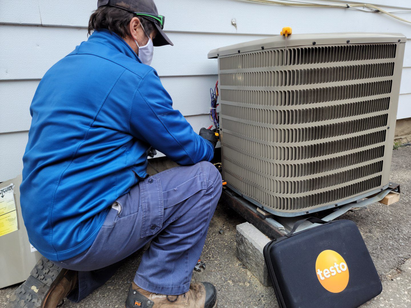 A man working on an air conditioner outside.